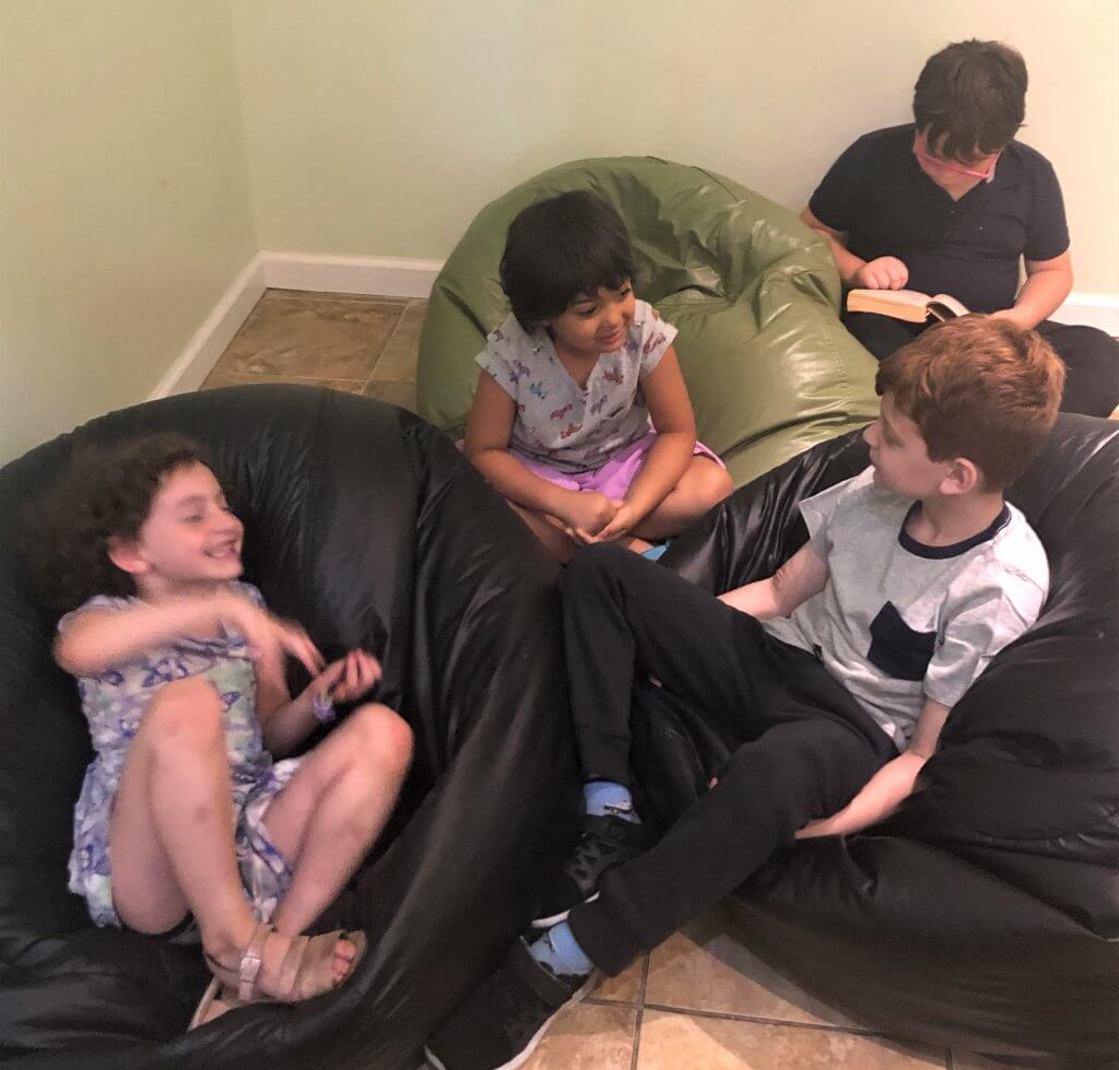 Four kids in beanbags telling spooky stories.