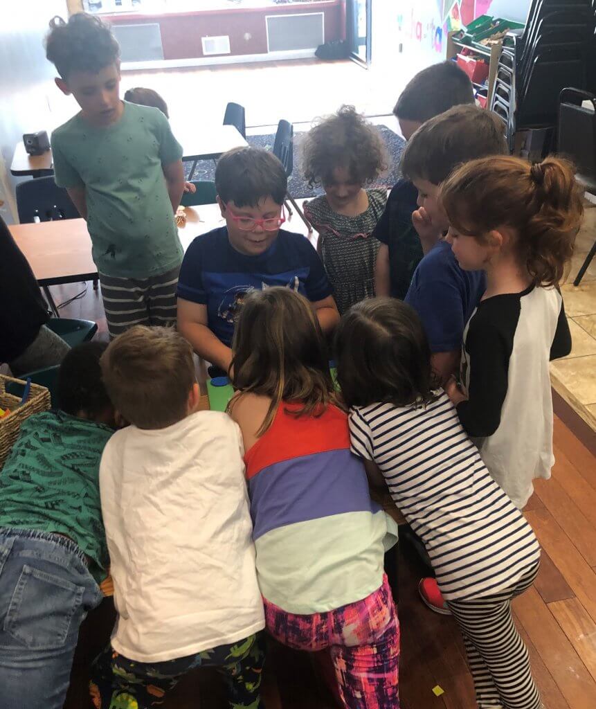 Kids gathered by felt board storyteller.