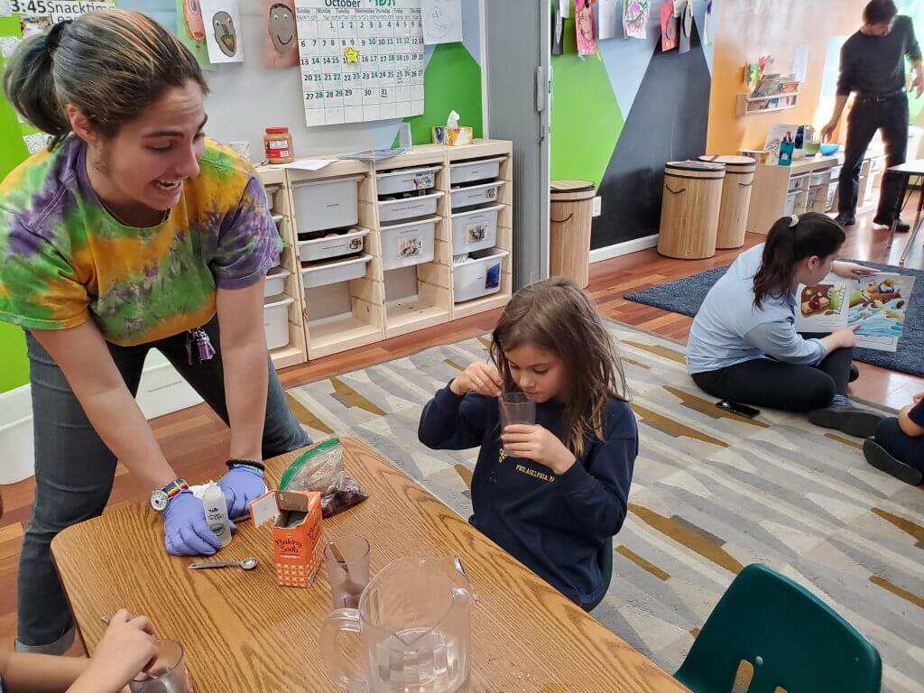 A student inspects colorful water that she turned clear again.