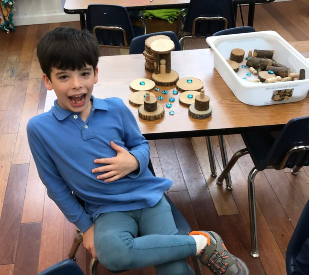 A first grader shows off his natural building blocks creation.