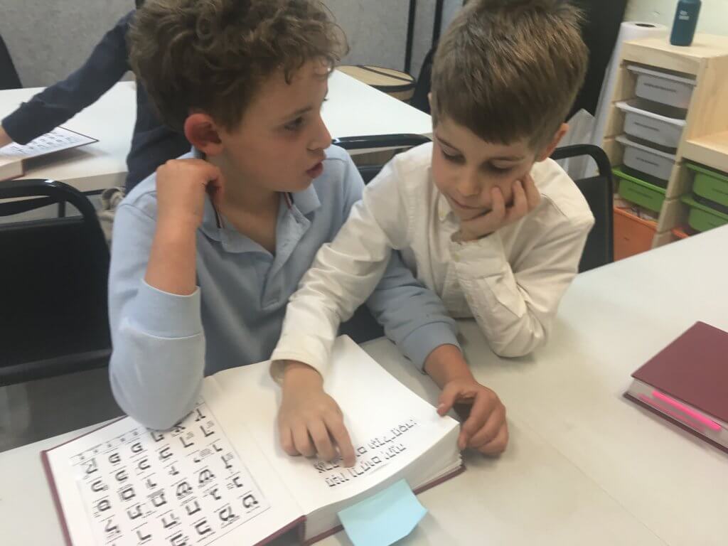 Two students working on mastering a tefilah (prayer) together.