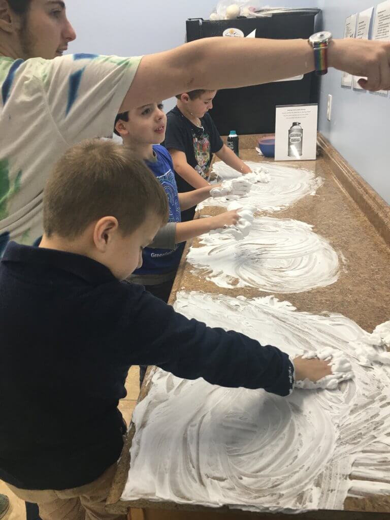 Practicing writing Hebrew letters in shaving cream.