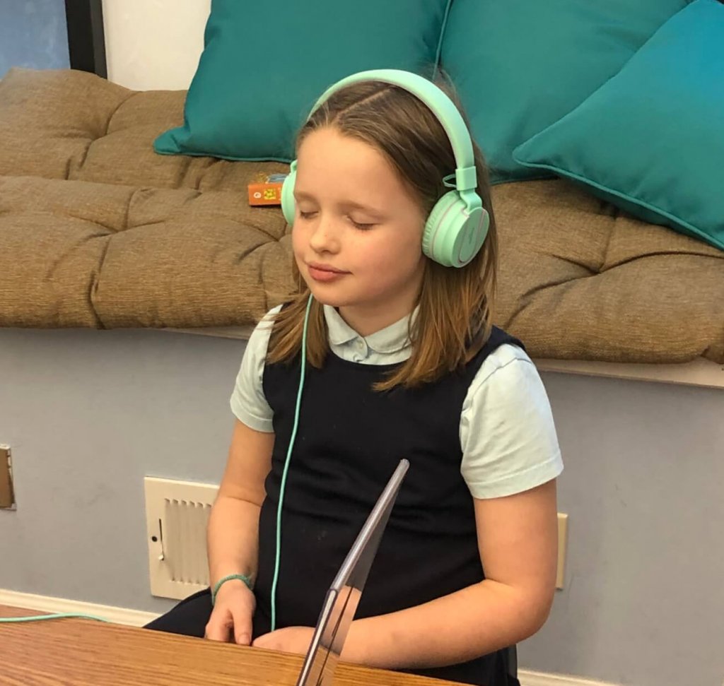 Second grade student peacefully meditating.