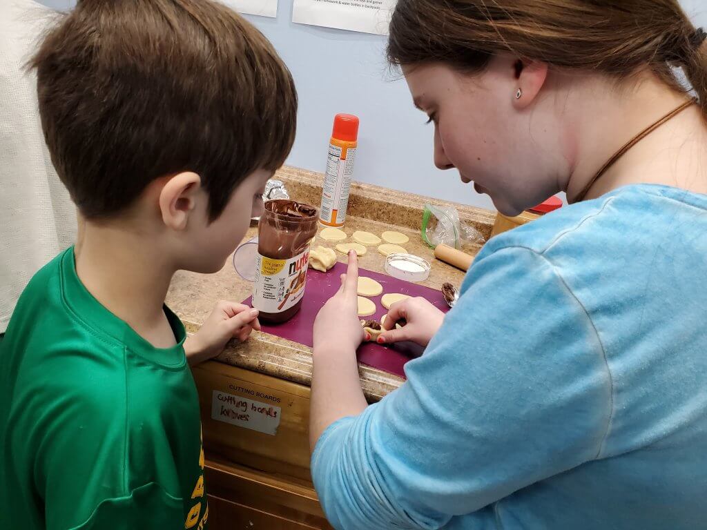 A BMitzvah student helps a 3rd grader make Hamantaschen.