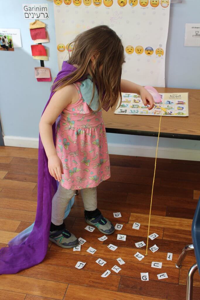 A pre-K student goes fishing for Hebrew letters.