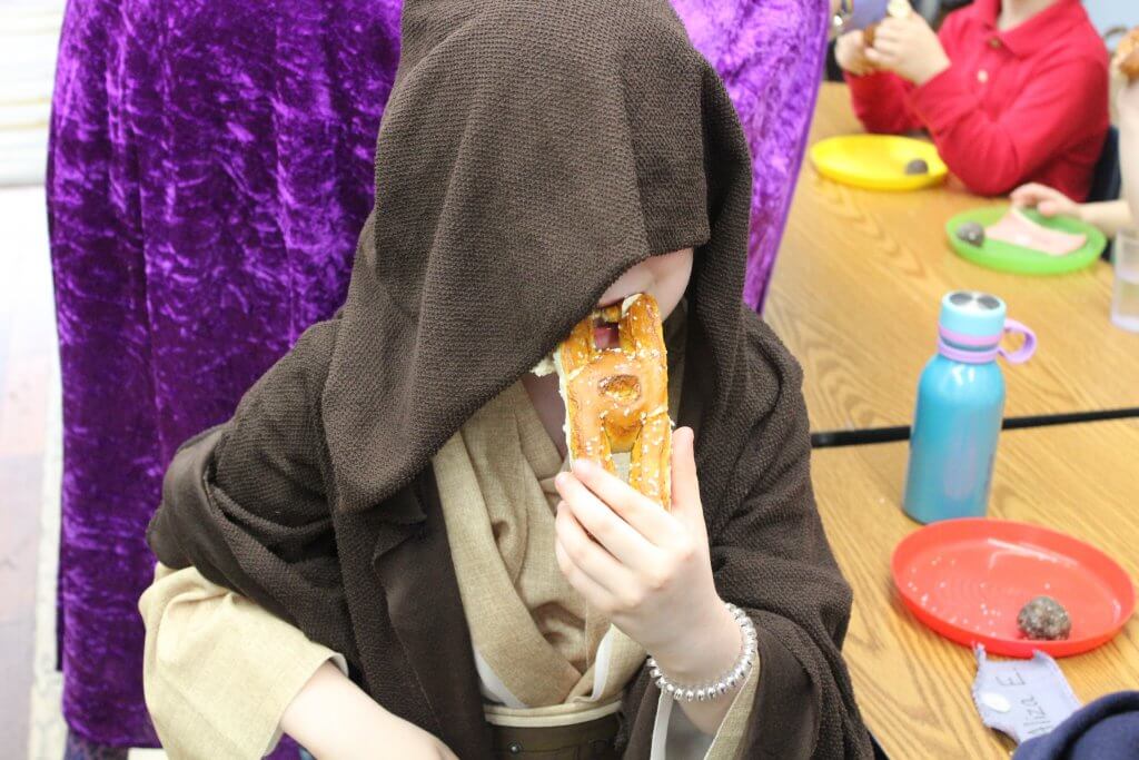 A jedi eating a soft pretzel at our Purim seuda.