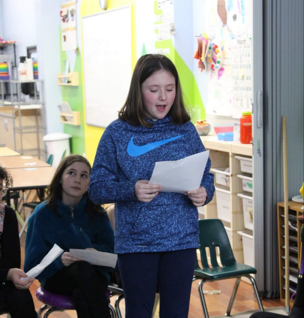 A BMitzvah student reading a sentence of Megilat Esther.