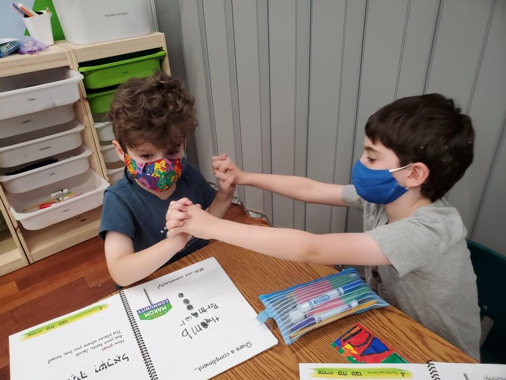 1st and 2nd grade students doing tefilah (prayer, music, and movement) together