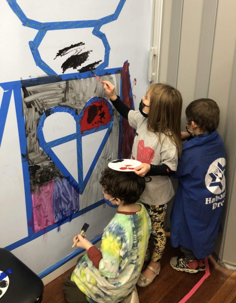 PreK, K, and 1st graders paint on their brit