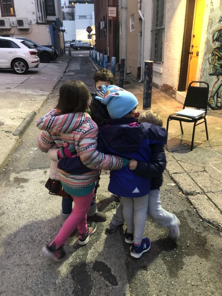 PreK and K kiddos hugging and watching the sunset during tefilah