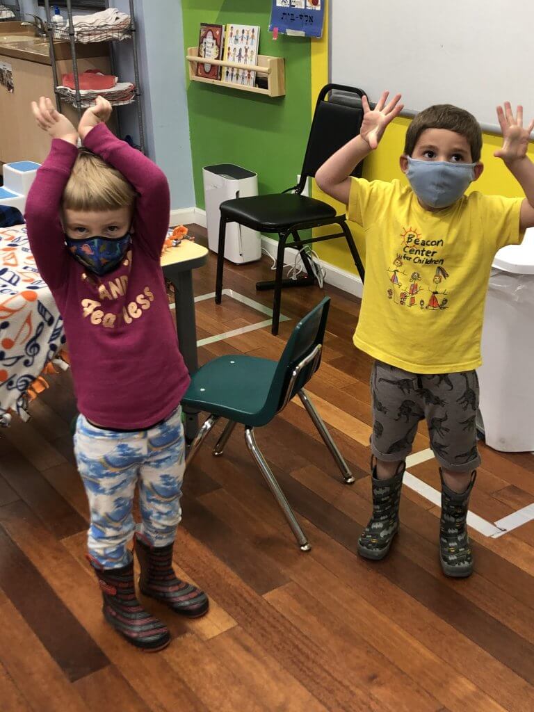 Two preK kiddos singing and dancing to tefilah